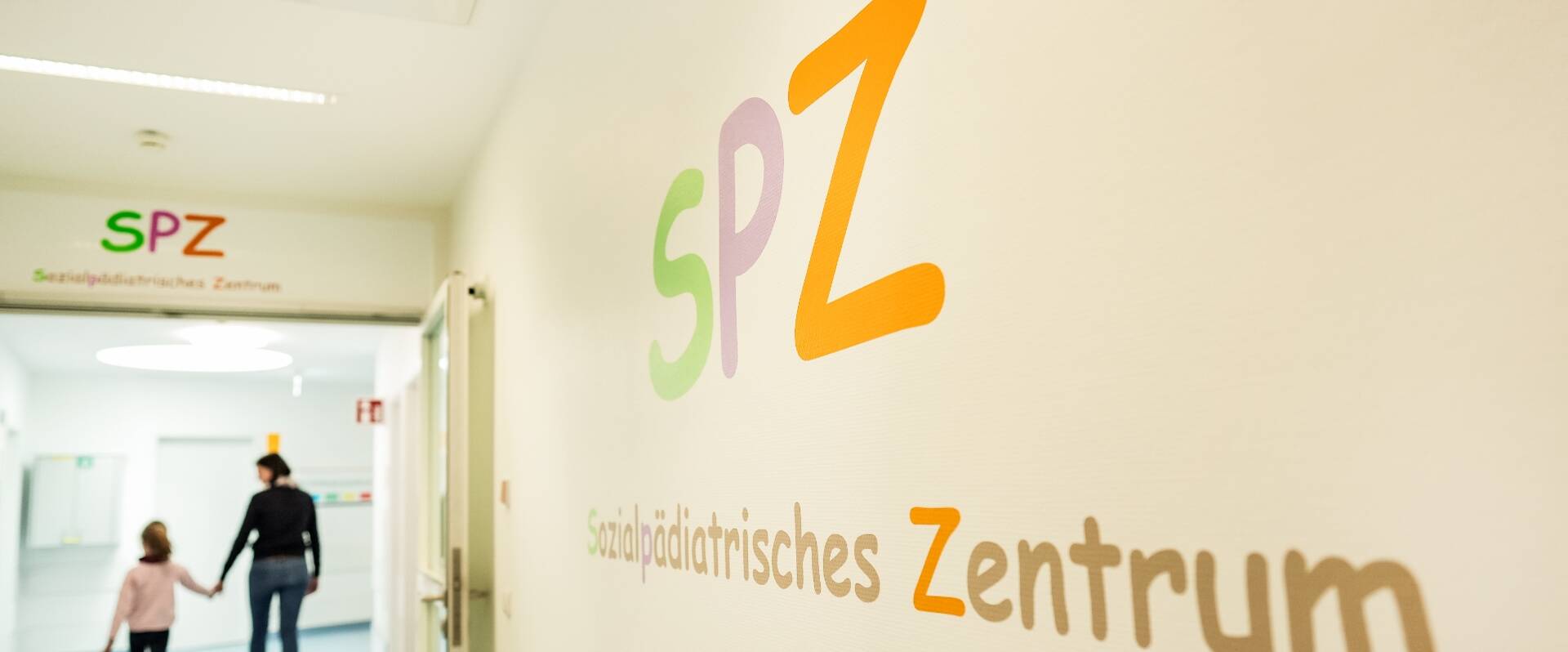 Schriftzug Sozialpädiatrisches Zentrum (SPZ) in bunten Farben auf selbiger Station