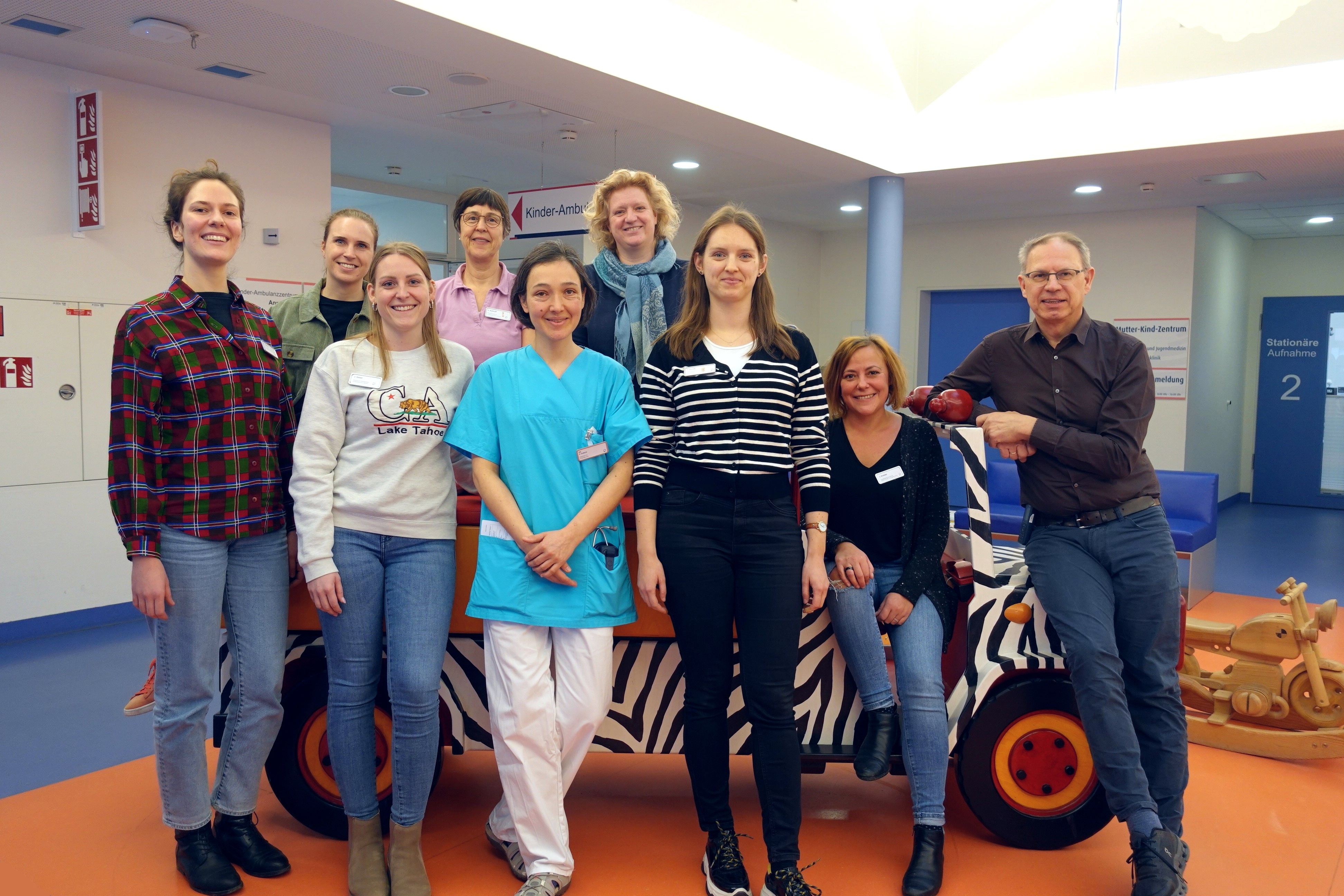 Mitarbeiterinnen aus dem Team des Sozialp&auml;diatrischen Zentrums mit Sektionsleiterin Dr. Nicola Kuhnke (hintere Reihe rechts) und Chefarzt Professor Dr. Patrick Gerner (rechts). Eggersgl&uuml;&szlig;